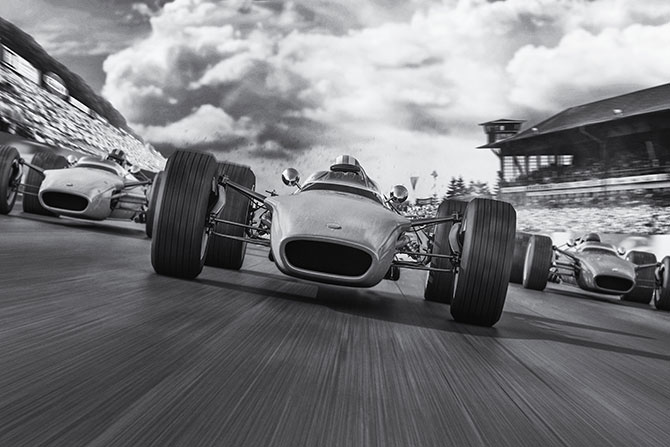 Off and Running; Black and white photo of vintage race cars speeding on a track, capturing motion and intensity under dramatic, cloudy skies with a blurred grandstand backdrop.