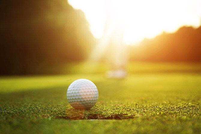 Golf ball being putt into hole