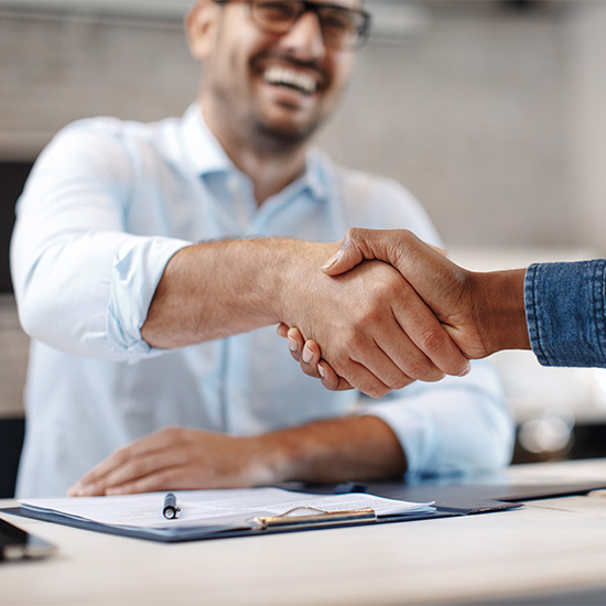 Smiling and shaking hands over contract